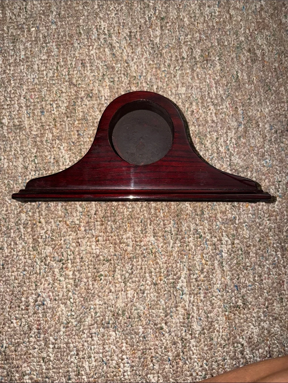 empty, polished wooden mantel clock case with a traditional arched profile